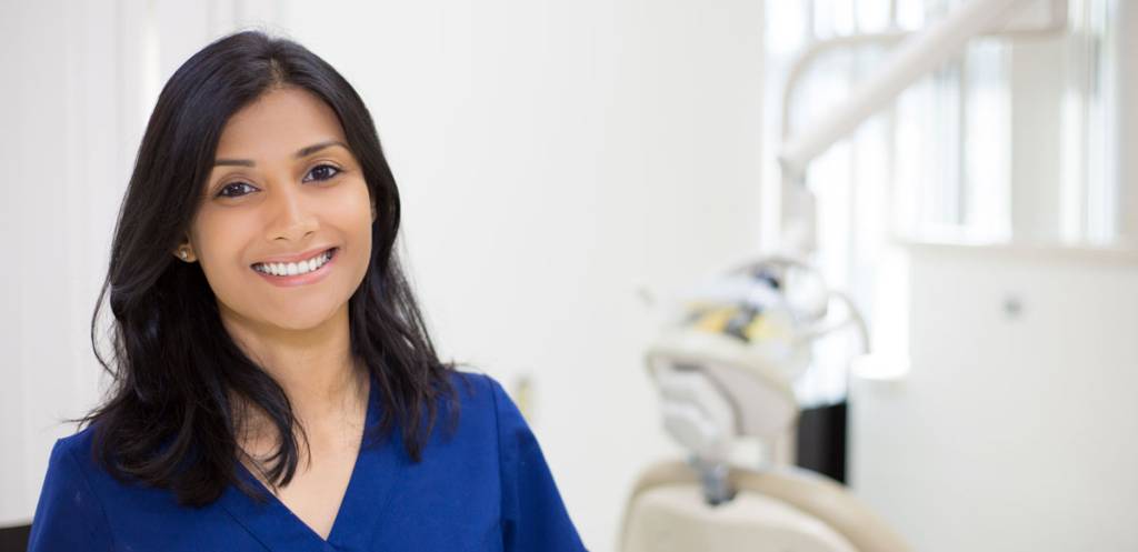 Smiling dentist in dental surgery